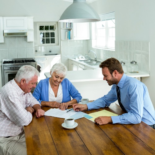 senior couple sitting at dining room table with advisor